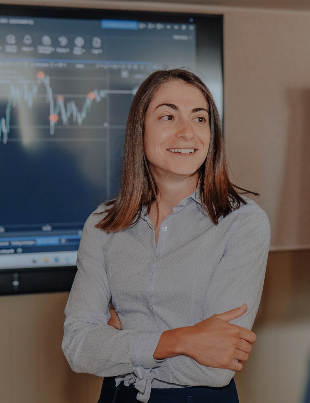 Cátia Fernandes, CEO e coach da DROPOWER, numa sessão presencial com um gráfico de mercado ao fundo